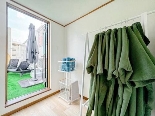 Habitación con ventana con cortina verde en R 新大阪 FUJI サウナ付きの５LDK　3つのお風呂でグループで楽しめます。, en Osaka