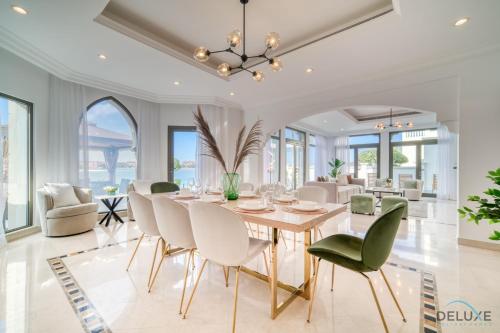 comedor con mesa y sillas en Seaside 5BR Villa with Assistant's Room and Beach Access on Palm Jumeirah by Deluxe Holiday Homes, en Dubái