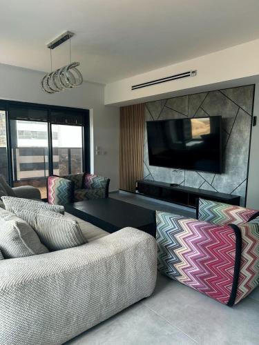 Sala de estar con 2 sofás y TV en O&O Group -Stellar Luxury 4BR APT en Bat Yam