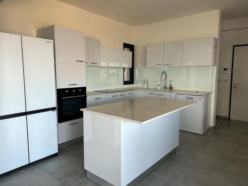 una cocina blanca con armarios blancos y fregadero en O&O Group -Stellar Luxury 4BR APT en Bat Yam