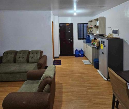 a living room with a couch and chairs and a kitchen at Deca homes condominium tisa Labangon in Cebu City