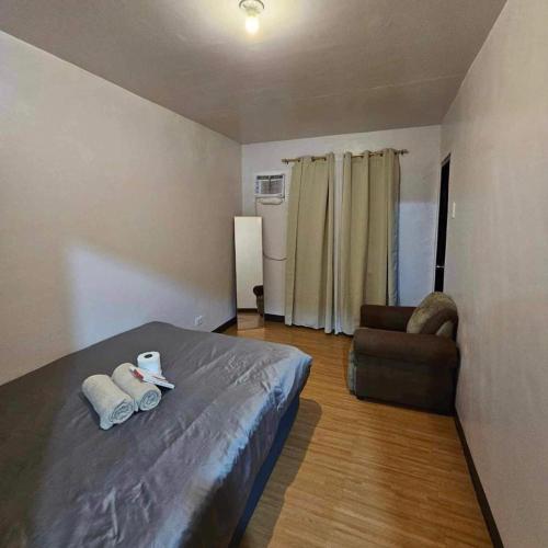 a bedroom with a bed and a couch and a chair at Deca homes condominium tisa Labangon in Cebu City