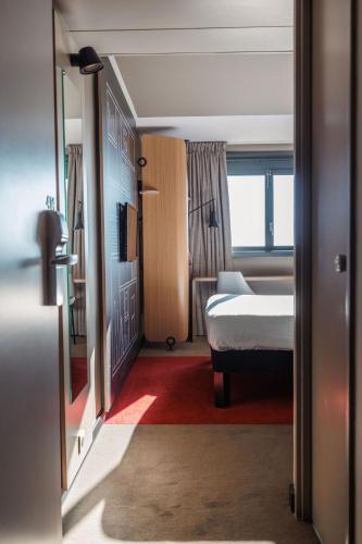 a hotel room with a bed and a window at ibis Valence Sud in Valence