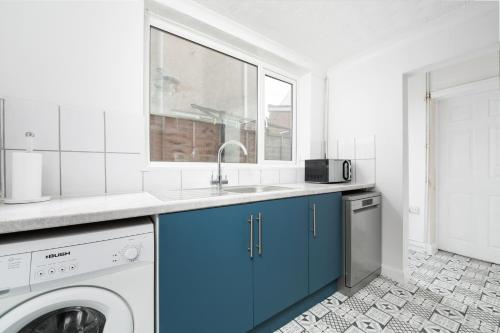 a kitchen with a sink and a washing machine at The Cosgrove - Central Cleethorpes in Cleethorpes