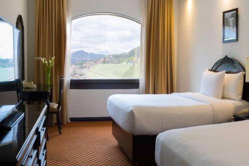 a hotel room with two beds and a window at Clarion Hotel Real Tegucigalpa in Tegucigalpa
