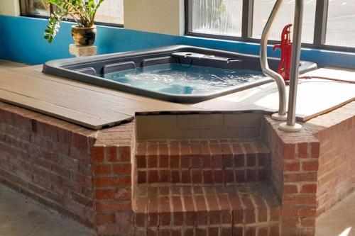 a hot tub in a room with a brick wall at Comfort Inn Duncansville - Altoona in Duncansville