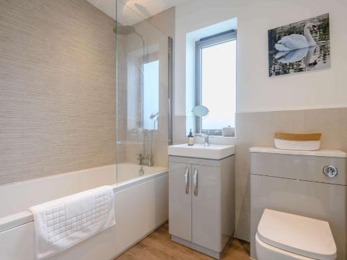 een badkamer met een bad, een toilet en een wastafel bij 2 Bed in East Bergholt 82398 in East Bergholt