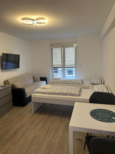 1 dormitorio con 2 camas y sofá en Neckar-Apart, en Heilbronn