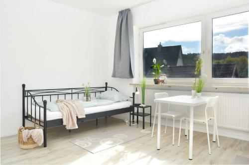 a bedroom with a bed and a table and a window at CO01-HI Apartment für Facharbeiter in Coburg in Coburg