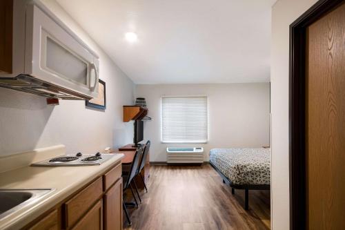 a kitchen with a sink and a table and a bed at WoodSpring Suites Augusta Fort Eisenhower in Augusta