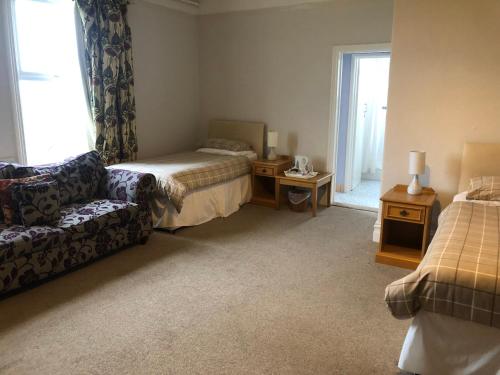 a living room with a bed and a couch at Highland Moors in Llandrindod Wells
