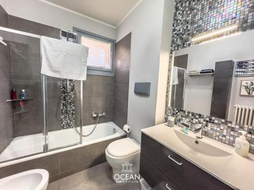 a bathroom with a sink and a toilet and a bath tub at GoldenSuitesItaly I Trento Suite 1 & Garage Privato in Trento