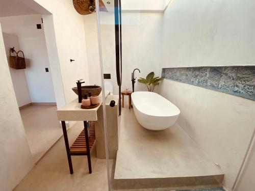 y baño con lavabo y bañera. en Villa Luasah, en Vila Praia Do Bilene