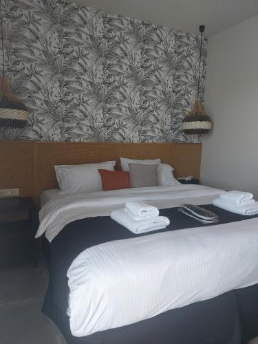 a bedroom with a large bed with towels on it at Chapter 02 Gallery Suites - ex GD Gallery Suites in Heraklio Town