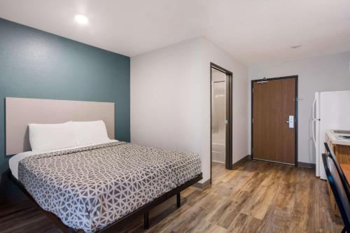 a bedroom with a bed and a door to a kitchen at WoodSpring Suites Columbia Fort Jackson in Royal Pines Estates