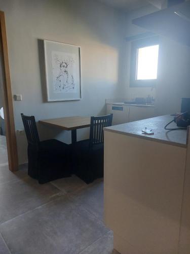 a kitchen with a table and chairs in a room at Chapter 02 Gallery Suites - ex GD Gallery Suites in Heraklio Town