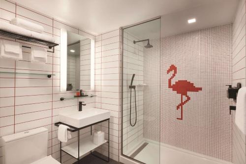 邁阿密的住宿－Radisson RED Miami Airport，白色的浴室设有水槽和淋浴。