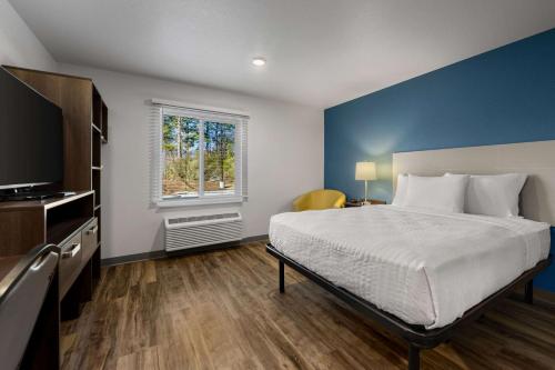 a bedroom with a large bed and a window at WoodSpring Suites Yorktown Newport News in Newport News
