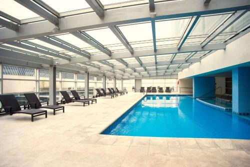 a large swimming pool with chairs in a building at Hilton Mendoza in Mendoza