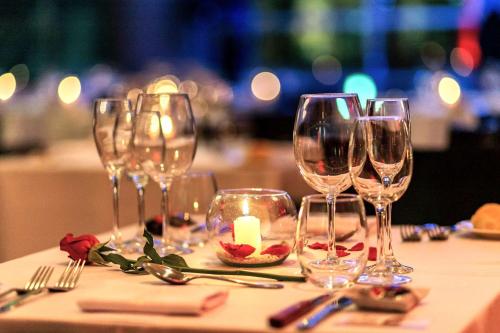 a table with wine glasses and a candle on it at Hilton Mendoza in Mendoza