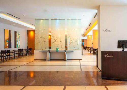 a lobby with tables and chairs in a building at Hilton Mendoza in Mendoza