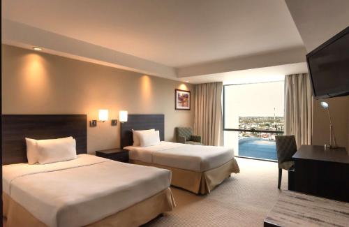 a hotel room with two beds and a balcony at Hilton Mendoza in Mendoza