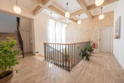 an indoor hallway with a staircase and potted plants at Vila Astoria in Luhačovice