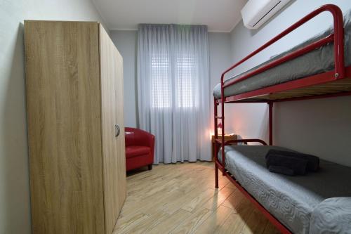 una camera con 2 letti a castello e una sedia rossa di Luxury Garibaldi ad Alghero