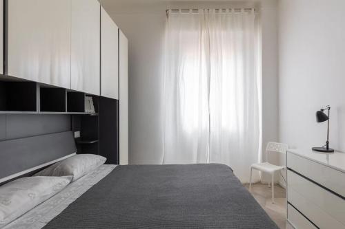 - une chambre blanche avec un lit et une fenêtre dans l'établissement Appartamento Turati 52, à Bologne