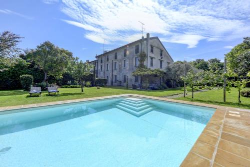 an image of a swimming pool in front of a house at Corte Vallio in Desenzano del Garda