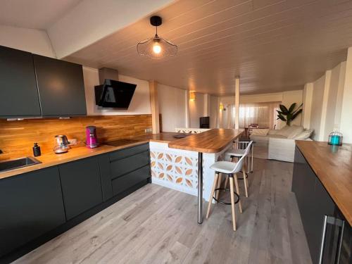 cocina con encimera de madera y mesa en La Suite au Village - 4/6 p - 90m2- 3 niveaux, en Gruissan