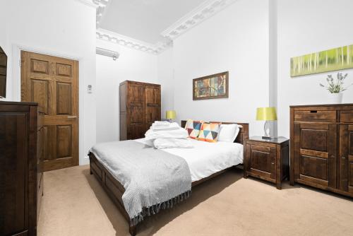 a white bedroom with two beds and a dresser at Apartment 1, 48 Bishopsgate by City Living London in London