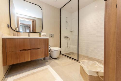 a bathroom with a shower and a toilet and a mirror at Luxury Villa w Pool Balcony in Regnum Golf Club in Çamlık