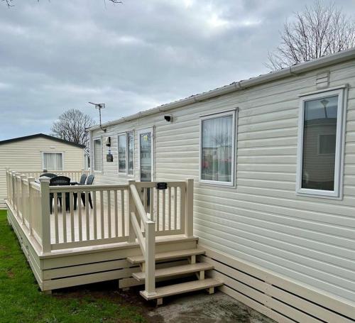 a white house with a porch and a deck at Beautiful Static Caravan Hoburne Devon Bay in Paignton