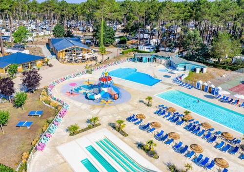 une vue aérienne d'une piscine dans un complexe hôtelier dans l'établissement Mobilhome les Dunes de Contis, à Saint-Julien-en-Born