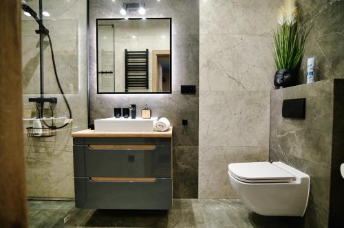 a bathroom with a sink and a toilet at Apartament No 61 Blue Holiday Home Zator in Zator