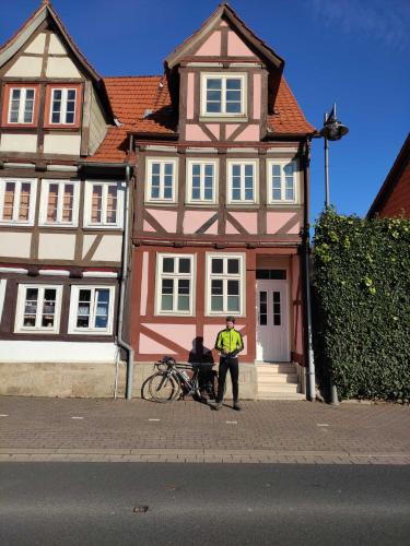 een man die voor een huis staat met een fiets bij Ferienhaus Rosa Blume in Hannoversch Münden
