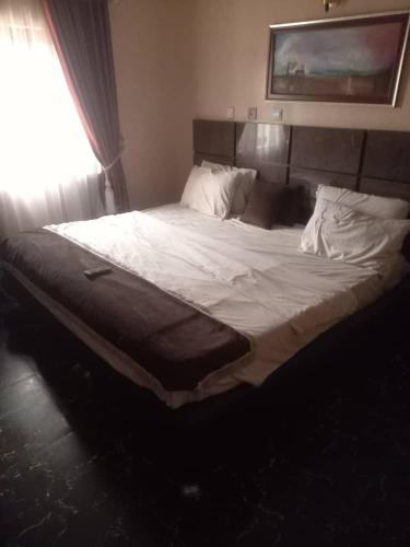 1 cama grande en un dormitorio con ventana en The Resident Hotel, en Owerri