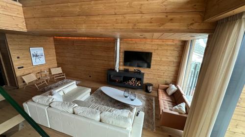 a living room with a white couch and a fireplace at ARTYSUR LUX VILLAGE CASA 2 in Sierra Nevada