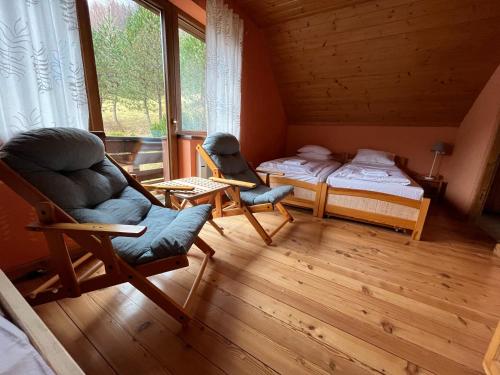 什切爾克的住宿－Malinowy Domek w Szczyrku，小屋内带两张床和椅子的房间
