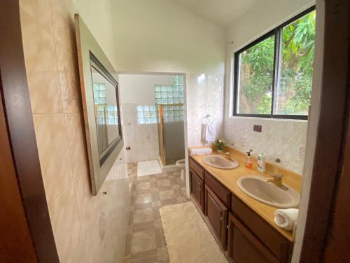 a bathroom with two sinks and a large window at Casa privada 4 habitaciones aires, piscina billar agua caliente 3 minutos de la playa in Río San Juan