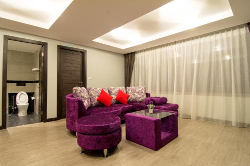 a living room with a purple couch and a table at The Blue Hotel - SHA Plus in Chalong 