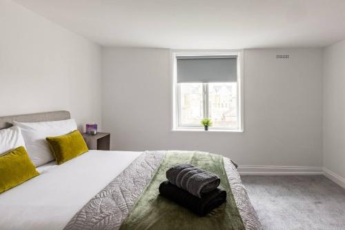 a white bedroom with a large bed with a window at Modern 2-Bed Gem in Picturesque Ramsgate Central Location in Kent