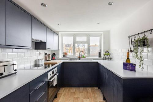 a kitchen with white and black cabinets and a window at Modern 2-Bed Gem in Picturesque Ramsgate Central Location in Kent