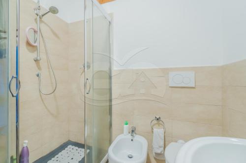 uma casa de banho com um chuveiro, um WC e um lavatório. em Trilocale Nicole - Goelba em Porto Azzurro