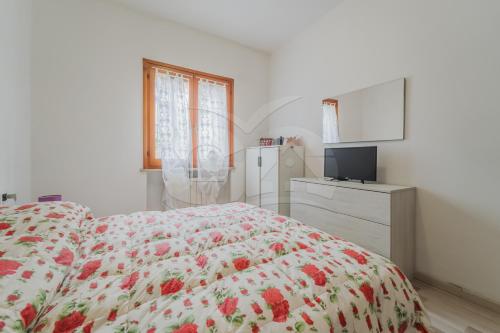 um quarto com uma cama, uma cómoda e uma televisão em Trilocale Nicole - Goelba em Porto Azzurro