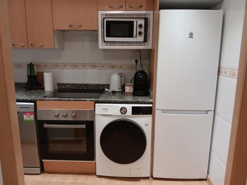 a kitchen with a white refrigerator and a microwave at Brisas del Mar in Salou