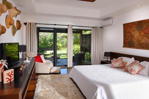 Cet appartement comprend une chambre avec un lit, une télévision et un salon. dans l'établissement Villa Kaz' Grenadine, à Bel Ombre