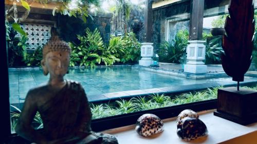 a pool in a garden with a statue in the foreground at Villa Kaz' Grenadine in Bel Ombre