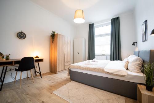 a bedroom with a bed and a desk and a deskablish at Stadtwohnung Helene in Messenähe in Essen